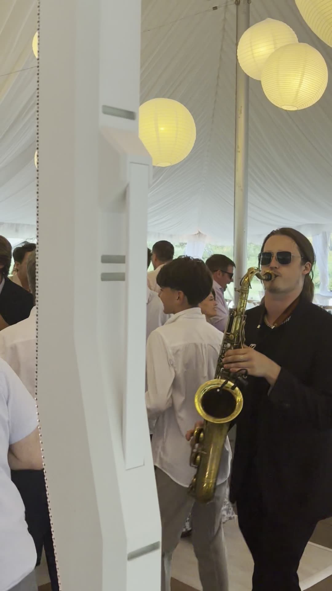 Josh Johnson performing live saxophone under neon stage lighting
